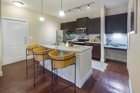 a kitchen with a large island with three stools